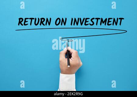 Geschäftsmann Hand schreiben Return on Investment auf blauem Hintergrund. Stockfoto