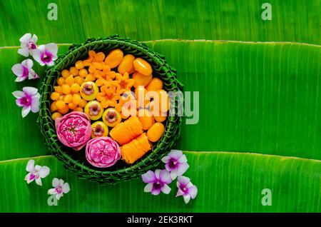 Thailändische Hochzeitsdesserts auf Bananenblatt Teller oder krathong schmücken mit Lotusblume für thailändische traditionelle Zeremonie auf Bananenblatt Hintergrund. Stockfoto