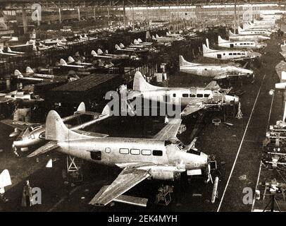 Ein altes gedrucktes Foto zeigt die Montagelinie in der De Havilland Flugzeugfabrik in Broughton, Chester (UK) - Reihen von Dove Leichtflugzeugen sind vorne mit Vampire Jet Trainern dahinter. Die Fabrik baute auch Chipmunks im kanadischen Design. Stockfoto