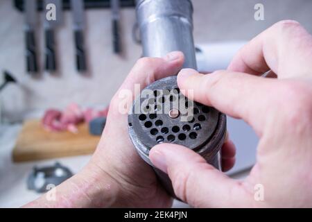 Vorbereitung von Hackfleisch.ein Mann sammelt ein Fleisch Grinder-Sets das Rost auf den Schaft, Stockfoto