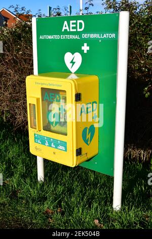 Automatisierter externer Defibrillator (AED) für die dringende Behandlung eines Herzinfarkts, auf Grasstreifen, Großbritannien Stockfoto