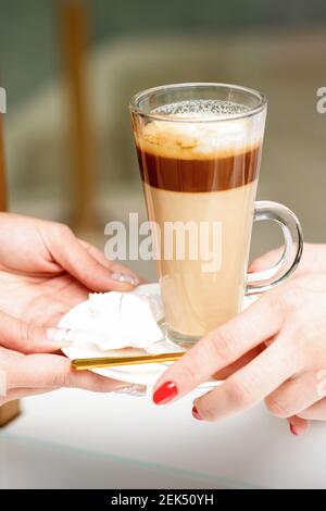 Nahaufnahme der Hände der Frau, die den Latte-Becher aus den Händen nimmt Eines Barista in einem Café Stockfoto