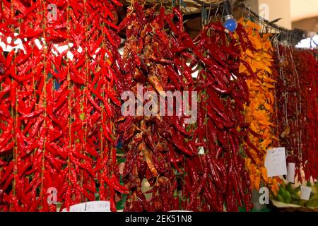 Bunte Chilischoten hängen an Fäden auf einem Funchal Markt Auf Madeira Stockfoto