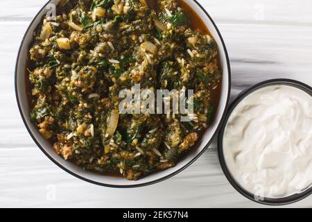 Türkische Küche geschmortes Hackfleisch mit frischem Spinat, Reis und Zwiebeln in einer Schüssel auf dem Tisch. Horizontale Draufsicht von oben Stockfoto