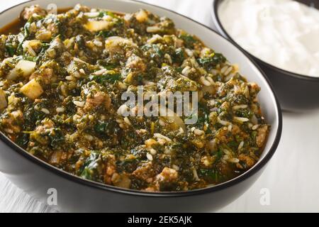 Türkische Küche geschmortes Hackfleisch mit frischem Spinat, Reis und Zwiebeln in einer Schüssel auf dem Tisch. Horizontal Stockfoto