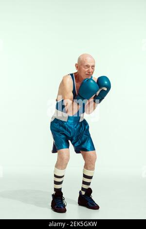 Champion. Senior Mann trägt Sportbekleidung Boxen auf Studio Hintergrund. Kaukasisches männliches Modell in guter Form bleibt aktiv und sportlich. Konzept von Sport, Aktivität, Bewegung, Wohlbefinden. Copyspace, Anzeige. Stockfoto