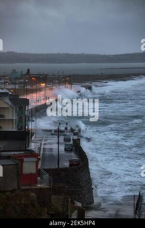 Riesige Wellen und heftiger Sturm springen über den Pier in der Küstenstadt Tramore, Waterford, Irland. Stockfoto