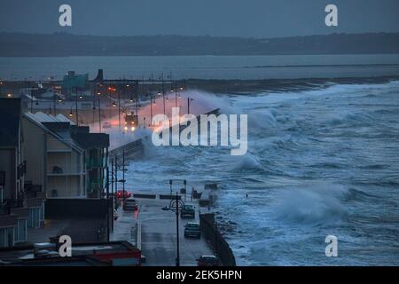 Riesige Wellen und heftiger Sturm springen über den Pier in der Küstenstadt Tramore, Waterford, Irland. Stockfoto