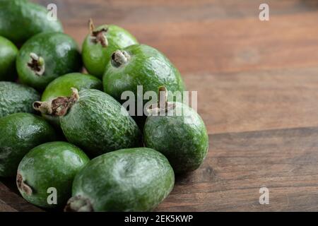 Frische Feijoa Früchte auf Holzplatte im Holzhintergrund Stockfoto