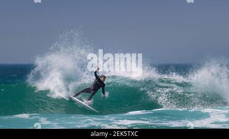 Ein Panoramabild spektakulärer Surfaktion, während ein Surfer eine Welle am Fistral in Newquay in Cornwall reitet. Stockfoto