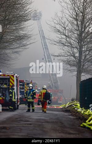 Flensburg, Deutschland. Februar 2021, 23rd. Feuerwehrleute löschen eine Bootshalle im Bezirk Mürwik, die am Morgen in Brand geraten war. Das teilweise eingestürzte Dach der Halle erschwerte die Löscharbeiten. Kredit: Frank Molter/dpa/Alamy Live Nachrichten Stockfoto