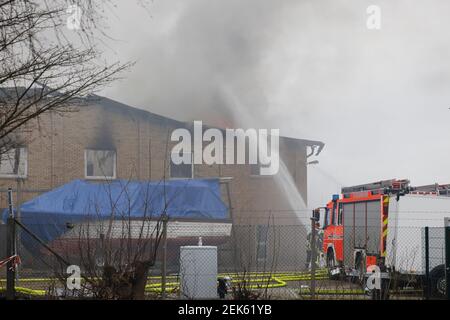 Flensburg, Deutschland. Februar 2021, 23rd. Feuerwehrleute löschen eine Bootshalle im Bezirk Mürwik, die am Morgen in Brand geraten war. Das teilweise eingestürzte Dach der Halle erschwerte die Löscharbeiten. Kredit: Frank Molter/dpa/Alamy Live Nachrichten Stockfoto