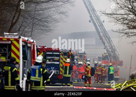 Flensburg, Deutschland. Februar 2021, 23rd. Feuerwehrleute löschen eine Bootshalle im Bezirk Mürwik, die am Morgen in Brand geraten war. Das teilweise eingestürzte Dach der Halle erschwerte die Löscharbeiten. Kredit: Frank Molter/dpa/Alamy Live Nachrichten Stockfoto