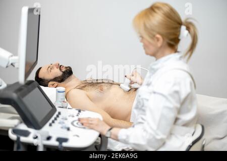 Arzt untersucht Leber des männlichen Patienten mit Ultraschall in Klinik Stockfoto