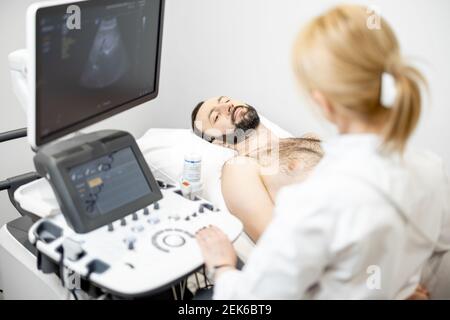 Arzt untersucht Leber des männlichen Patienten mit Ultraschall in Klinik Stockfoto