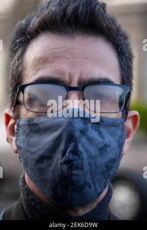 Mann trägt Maske mit aufgedampfter Brille Stockfoto