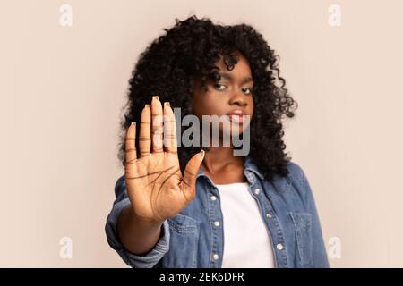 Schwarze Frau zeigt ihre Handfläche, Stop-Geste Stockfoto