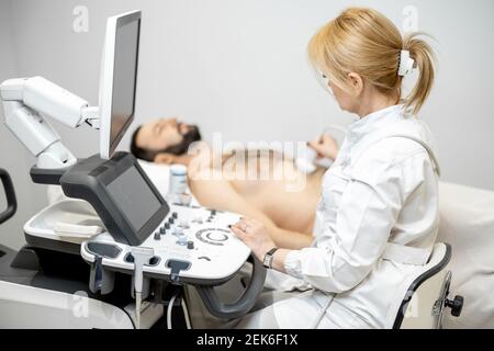 Arzt untersucht Leber des männlichen Patienten mit Ultraschall in Klinik Stockfoto