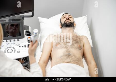 Arzt untersucht Leber des männlichen Patienten mit Ultraschall in Klinik Stockfoto