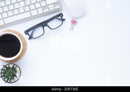 Weiß Schreibtisch im Büro mit Laptops, Smartphones und andere Arbeiten mit einer Tasse Kaffee. Ansicht von oben mit der Kopie Platz für die Eingabe des Textes. Designer Arbeitsbereich Stockfoto