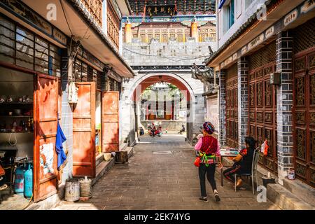 Dali China , 6 Oktober 2020 : Zhoucheng alten Dorf Gasse Blick mit Bai Minderheit Frau in traditioneller Kleidung in Zhoucheng Dali Yunnan China Stockfoto