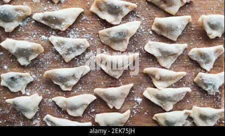 Traditionelle türkische Manti. Auf dem Holztisch steht ein berühmter türkischer Food-Manti. Nahaufnahme von handgefertigten Manti. Traditionelle türkische Knödel. Knödel mit mir Stockfoto