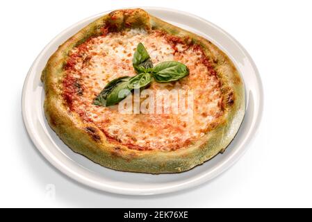 Grüne Pizza mit gefärbtem Teig mit Spinat. Garniert mit Mozzarella, Tomaten und Basilikumblättern. Isoliert auf weiß Stockfoto