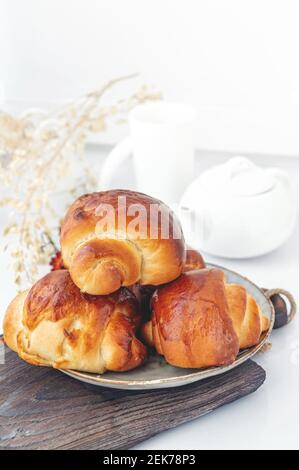 Zimtbrötchen Weihnachten backen Brötchen auf einem hölzernen Frühstückstisch auf einem Teller. Die frischesten hausgemachten Kuchen Close-up. Stockfoto