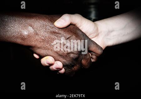 Handschlag zwischen einem Afrikaner und einem Europäer Stockfoto