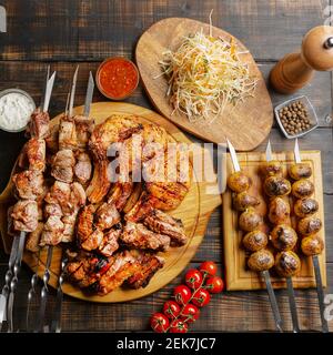 Schaschlik Kebab mit Kohlspieß, Sauce und Zwiebeln anrichten Stockfoto