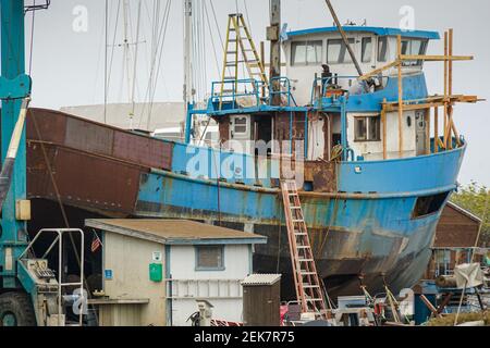 Rostiger alter Trawler, der sich in einem Trockendock festgemacht hat Stockfoto