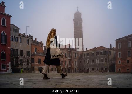 Venedig, Italien. 23rd. Februar 2020. Bürgerspaziergang auf einem Platz, während die Stadt am 23. Februar 2021 in Venedig, Italien, in dichten Nebel getaucht ist © Simone Padovani / Behind Venice / Alamy Live News Stockfoto