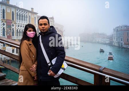 Venedig, Italien. 23rd. Februar 2020. Besucher posieren für ein Porträt auf der Brücke der Accademia, während die Stadt am 23. Februar 2021 in Venedig, Italien, in dichten Nebel getaucht ist © Simone Padovani / Behind Venice / Alamy Live News Stockfoto