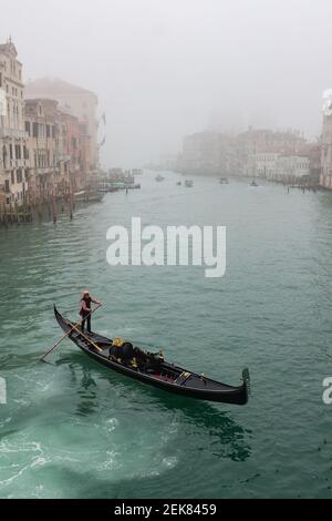 Venedig, Italien. 23rd. Februar 2020. Eine Gondel fährt den Canale Grande, während die Stadt am 23. Februar 2021 in Venedig, Italien, in dichten Nebel getaucht ist. © Simone Padovani / Behind Venice / Alamy Live News Stockfoto