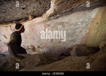 (210223) -- SYDNEY, Feb. 23, 2021 (Xinhua) -- das am 15. Juli 2016 aufgenommene Aktenfoto zeigt einen Ureinwohner, der ein Felsbild von Känguru in der Kimberley Region, Australien, betrachtet. Ein zwei Meter langes Gemälde eines Kängurus in der Kimberley-Region Westaustraliens gilt seit 17.300 Jahren als Australiens ältestes intaktes Felsbild.naturalistische Tierdarstellungen sind ein gängiges Thema der ältesten datierten Felskunst der Welt. In einem Artikel, der am Dienstag in Nature Human Behaviour veröffentlicht wurde, Ein Forscherteam um die Universität Melbourne verwendete das Radiokarbon aus 27 Schlammwespennestern aus dem Jahr 16 Stockfoto