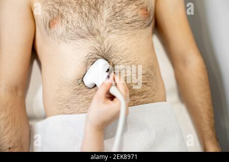 Arzt untersucht Leber des männlichen Patienten mit Ultraschall in Klinik Stockfoto