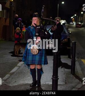 Piper Louise Marshall spielt auf ihren Dudelsäcken, und Nachbarn auf der Straße in Leith stehen in ihren Türen, um für Heldenhund zu klatschen. Dies ist auf eine nationale Sperre von 3rd bezüglich eines mutierten Stammes von covid-19 zurückzuführen. Kredit: Euan Cherry Stockfoto