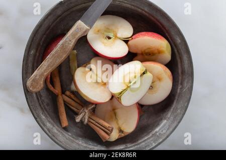 Frisch geschnittene Äpfel mit Zimtstangen auf Marmorboden. Draufsicht. Stockfoto