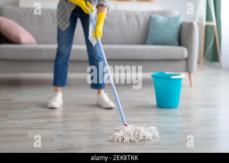 Cropped Ansicht der jungen Hausfrau Waschtisch mit Mopp zu Hause, Nahaufnahme der Beine. Professionelles Hausreinigungskonzept Stockfoto