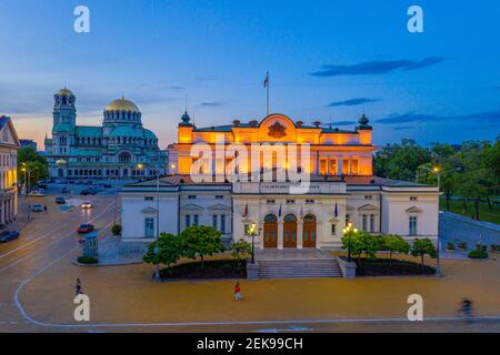 Nachtansicht der Nationalversammlung der Republik Bulgarien und Alexander Nevski Kathedrale in Sofia. Zeichen übersetzt - Einheit macht Macht Stockfoto