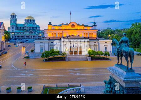 Nachtansicht der Nationalversammlung der Republik Bulgarien und Alexander Nevski Kathedrale in Sofia. Zeichen übersetzt - Einheit macht Macht Stockfoto