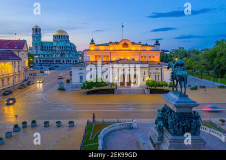 Nachtansicht der Nationalversammlung der Republik Bulgarien und Alexander Nevski Kathedrale in Sofia. Zeichen übersetzt - Einheit macht Macht Stockfoto