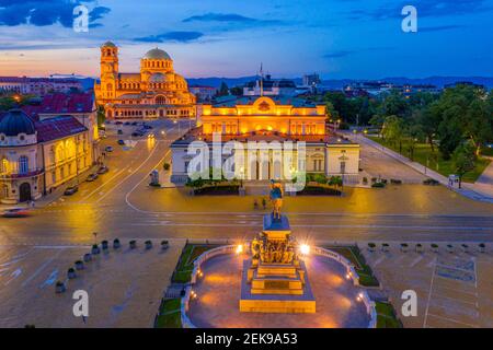 Nachtansicht der Nationalversammlung der Republik Bulgarien und Alexander Nevski Kathedrale in Sofia. Zeichen übersetzt - Einheit macht Macht Stockfoto