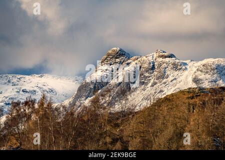 Dramatische schneebedeckte Bergspitze in atemberaubenden Lake District Winterlandschaft mit dunklen Vorahnungen Wolken am Himmel! Stockfoto