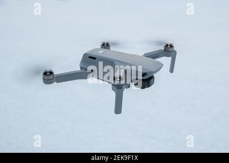 Kharkiv, Ukraine - 21. Februar 2021: DJI Mavic Mini 2 Drohne aus nächster Nähe. Neue Quadcopter-Gadget auf weißem Schnee Winter Hintergrund rechts suchen Stockfoto