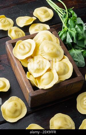 Hausgemachte Ravioli mit Basilikum und Tomaten Set, in Holzkiste, auf alten dunklen Holztisch Hintergrund Stockfoto
