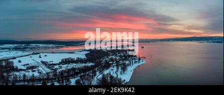 Deutschland, Baden-Württemberg, Radolfzell, Luftaufnahme der schneebedeckten Halbinsel Mettnau bei Sonnenuntergang Stockfoto