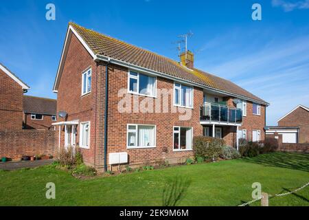 Kleiner moderner 2-stöckiger Wohnblock mit Gemeinschaftsgras an der Vorderseite, in einer ruhigen Wohngegend in Rustington, West Sussex, England, Großbritannien. Stockfoto