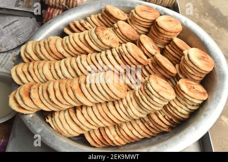 Dhaka. Februar 2021, 23rd. Das Foto vom 23. Februar 2021 zeigt ein Tablett voller Bakorkhani zum Verkauf in einem Geschäft in Dhaka, Bangladesch. Bakorkhani, ein rundes knuspriges Fladenbrot, wird hauptsächlich aus Mehl, Milch, Salz, Käse und süßen Zutaten hergestellt. Es ist ein gemeinsames Frühstück Snack in der Stadt. Quelle: Xinhua/Alamy Live News Stockfoto