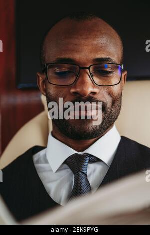 Junger Geschäftsmann mit Brille im Privatjet Stockfoto